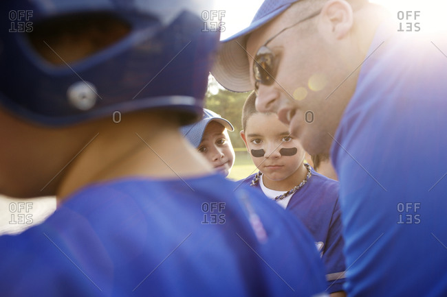 A coach gives a pep talk to a little league team