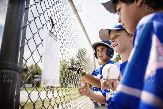 Little league players check their lineup on a list