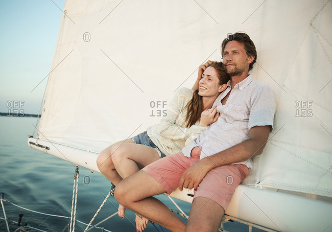 Couple relaxing on the boom of a sail boat
