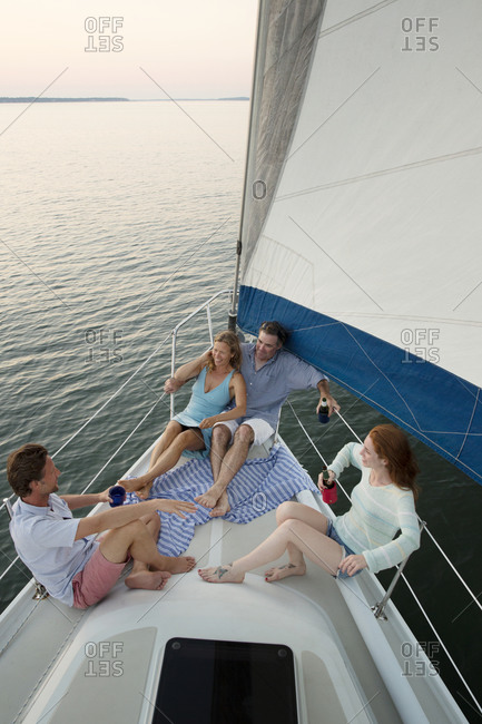 Group of friends relaxing on deck of private yacht