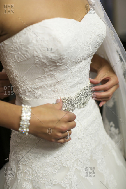 A bride adjusts her belt