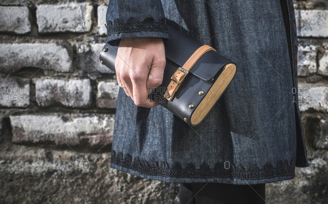Woman\'s hand holding leather handbag