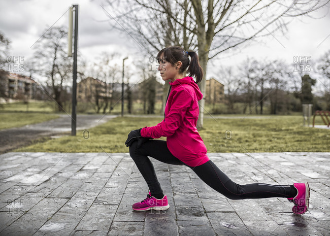 Young woman in a high lunge in park
