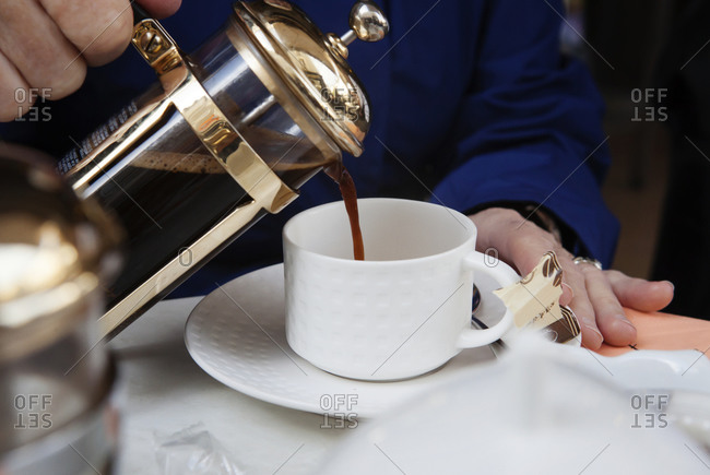 Person pouring coffee from a French press