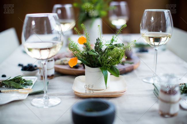 Table setting with fresh herbs and white wine