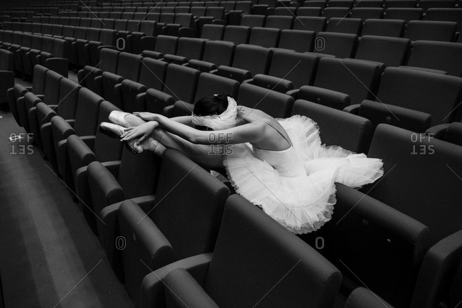 Costumed ballet dancer resting in theater seats