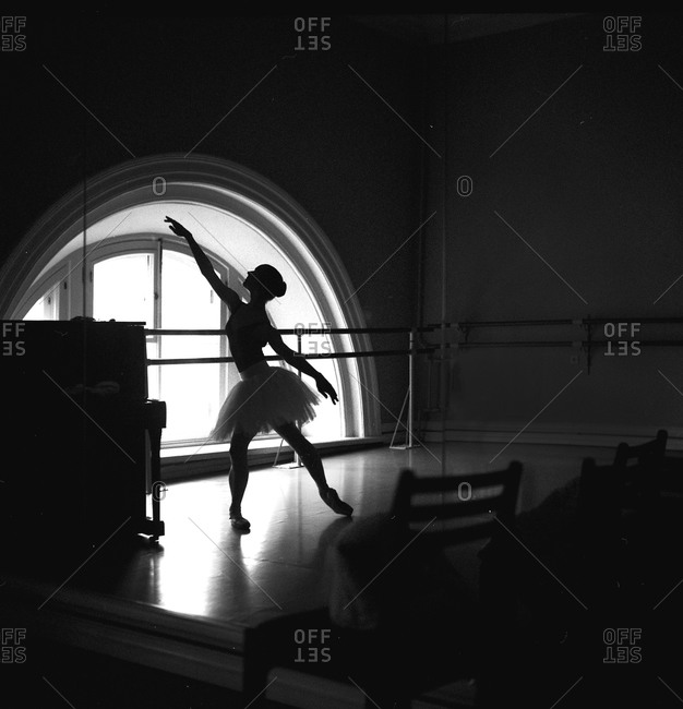 Silhouetted dancer practicing in studio