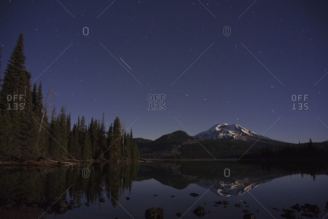 Shooting star over pristine mountain lake