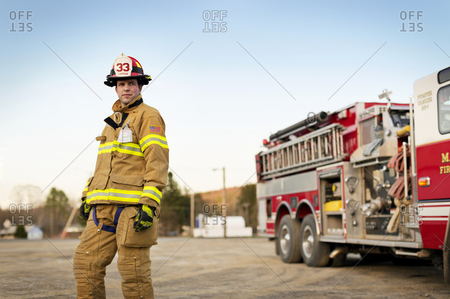 A fireman standing next to a fire engine
