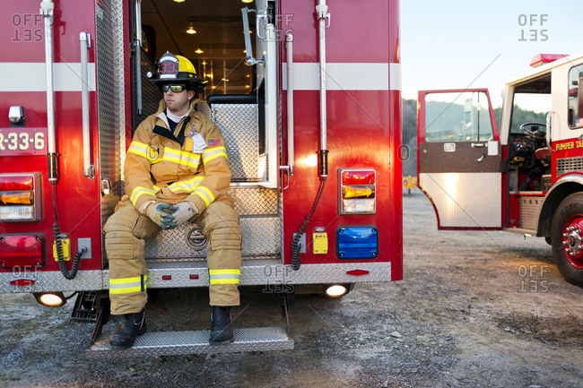 A firefighter seated in the back of a fire truck
