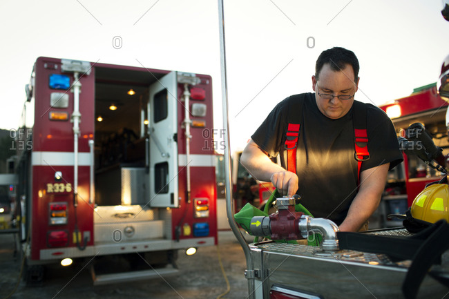 A fireman checks out a fire hose on a truck