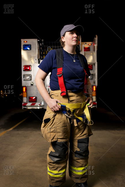 A firewoman stands in front of a fire truck