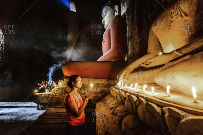 Woman lighting candle in a Buddhist temple
