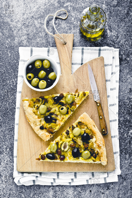 Slices of raisin and olive foccacia on a cutting board