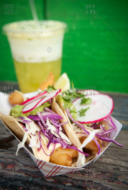 Fish tacos and a drink on a wooden table