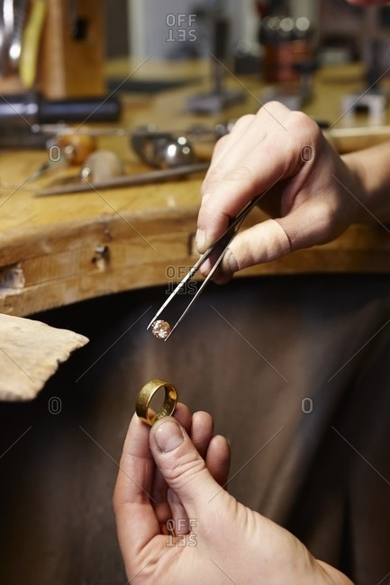 Goldsmith in workshop with gemstone and golden ring
