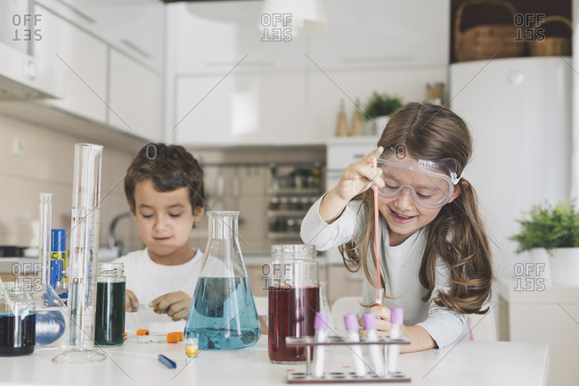 Boy and girl playing science experiments at home