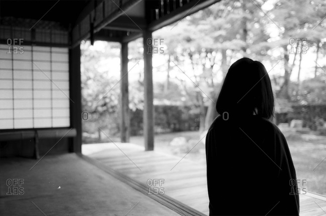 A woman stands on a porch in Japan
