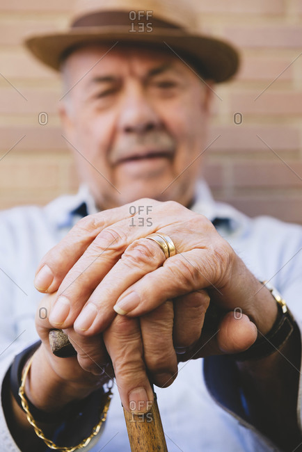 Old man with hat resting on cane