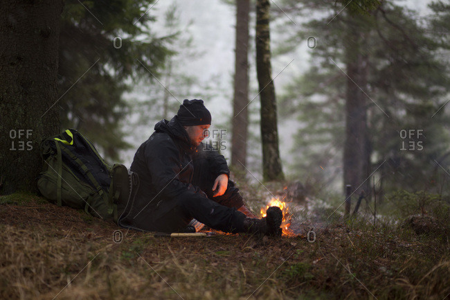 Man sitting by fire in the forest