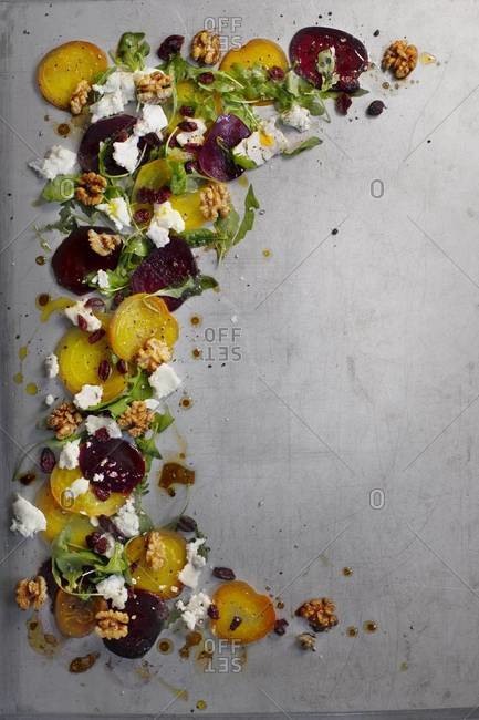 A stripe of beet salad with goat cheese and buttery walnuts
