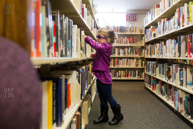 Girl browsing library shelf for books