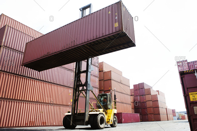Forklift in freight shipping yard moving load