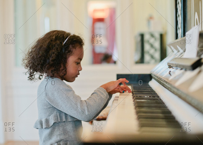 Little girl practicing on the piano