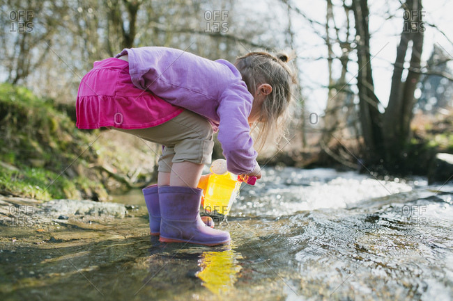 A little girl plays in a stream