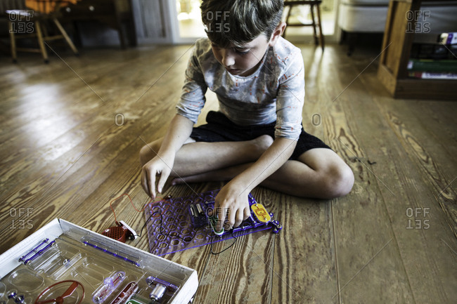 A boy plays with an electronics kit