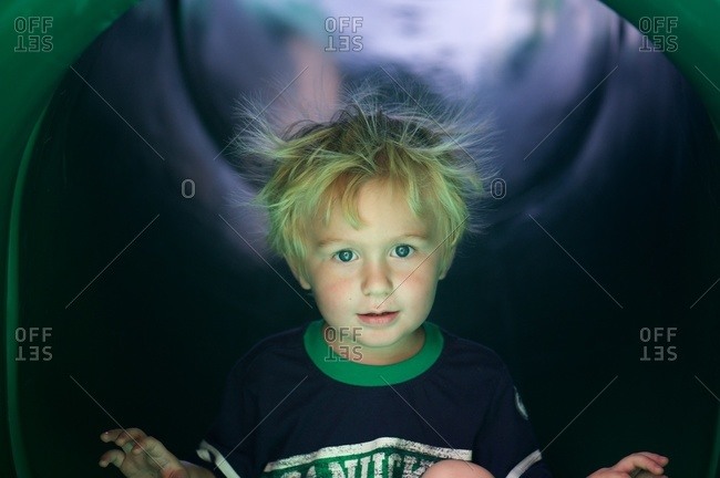 Little boy on slide with static in his hair