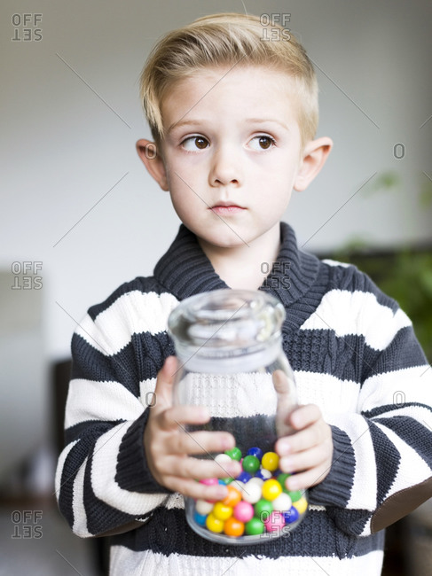 Boy holding glass jar with candies