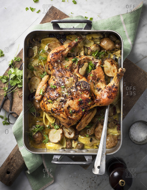 Whole roasted chicken with potatoes and artichokes