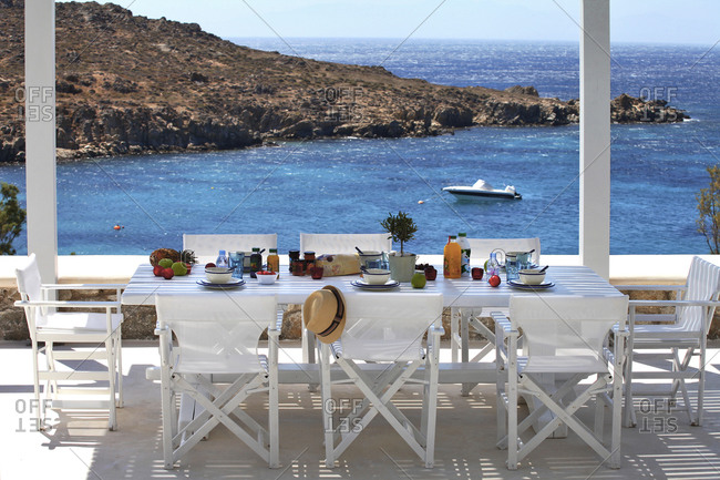 An outdoor dining terrace overlooking the sea in Mykonos, Greece