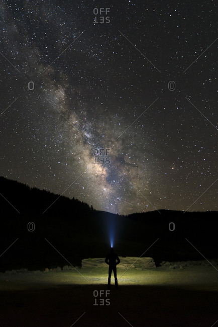 A lone camper watches the Milky Way set over their campsite