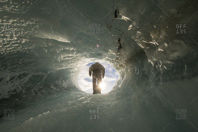 Man in tunnel in iceberg in Antarctica