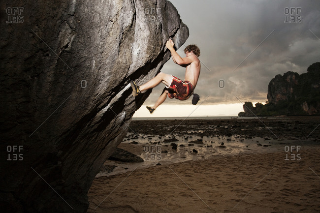 Man climbing difficult rock face