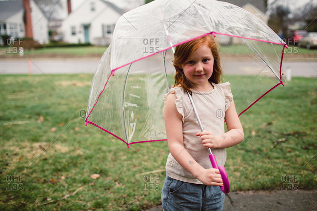 A little girl holds a clear umbrella