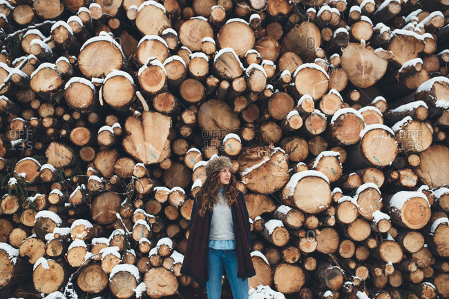 Woman wearing a fur hat in front of lumber