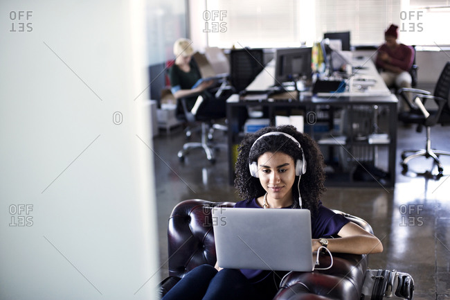 Young woman listening to music in an office