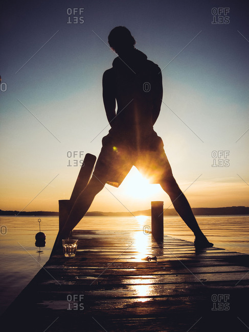 A man stands with his legs apart on a dock