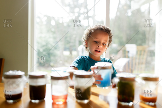 Boy taking a glass jar from the table