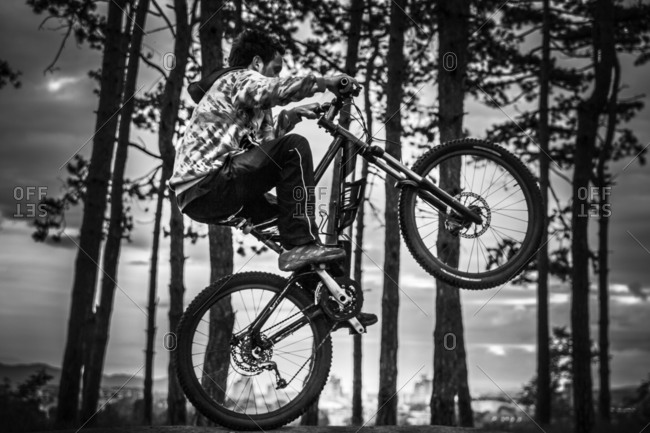 Young man rides his mountain bike on the back wheel in the town of Kraljevo