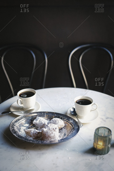 Two cups of coffee and a tray of sugared pastries