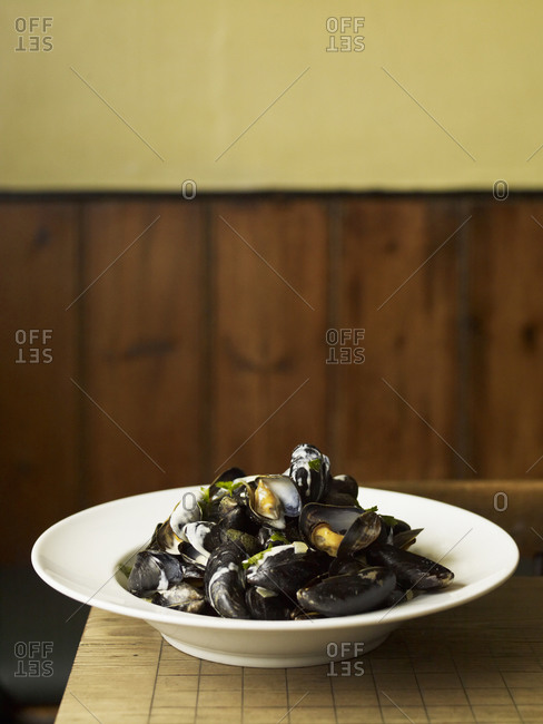 A traditional dish of steamed mussels, seafood on a white plate Pub food