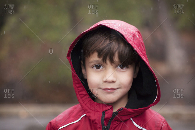 Boy in hooded red rain coat