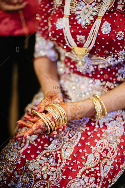Indian bride putting on golden bracelets