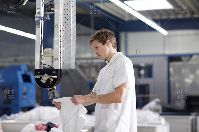 Worker in laundry at drying machine