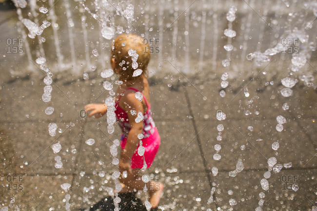 Little girl walking at a splash pad