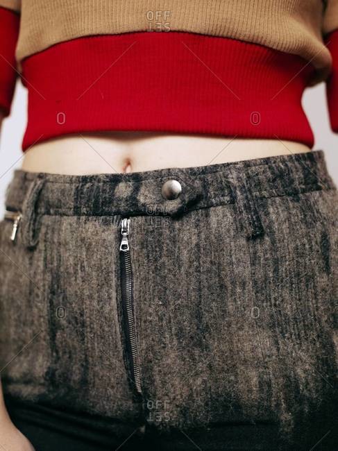 A woman wearing a crop top and high waisted jeans